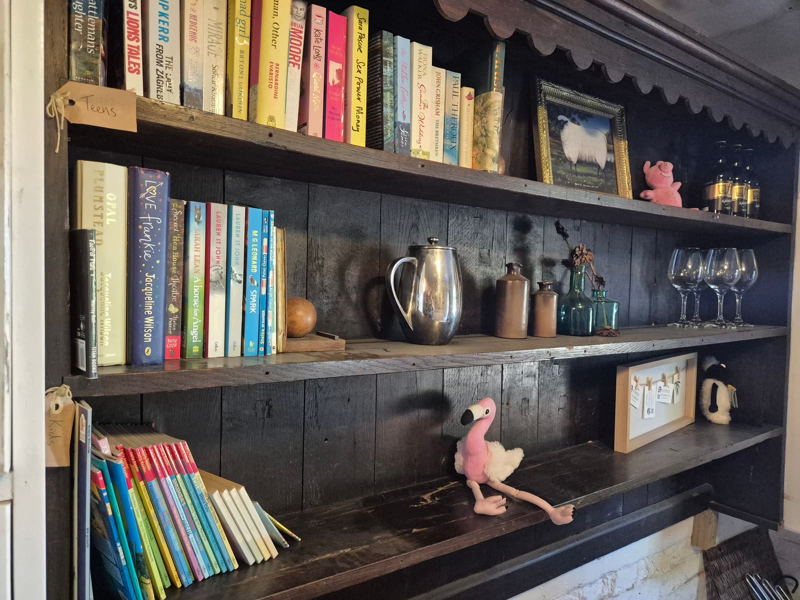 Rustic shelves of books and provisions in the honesty shop