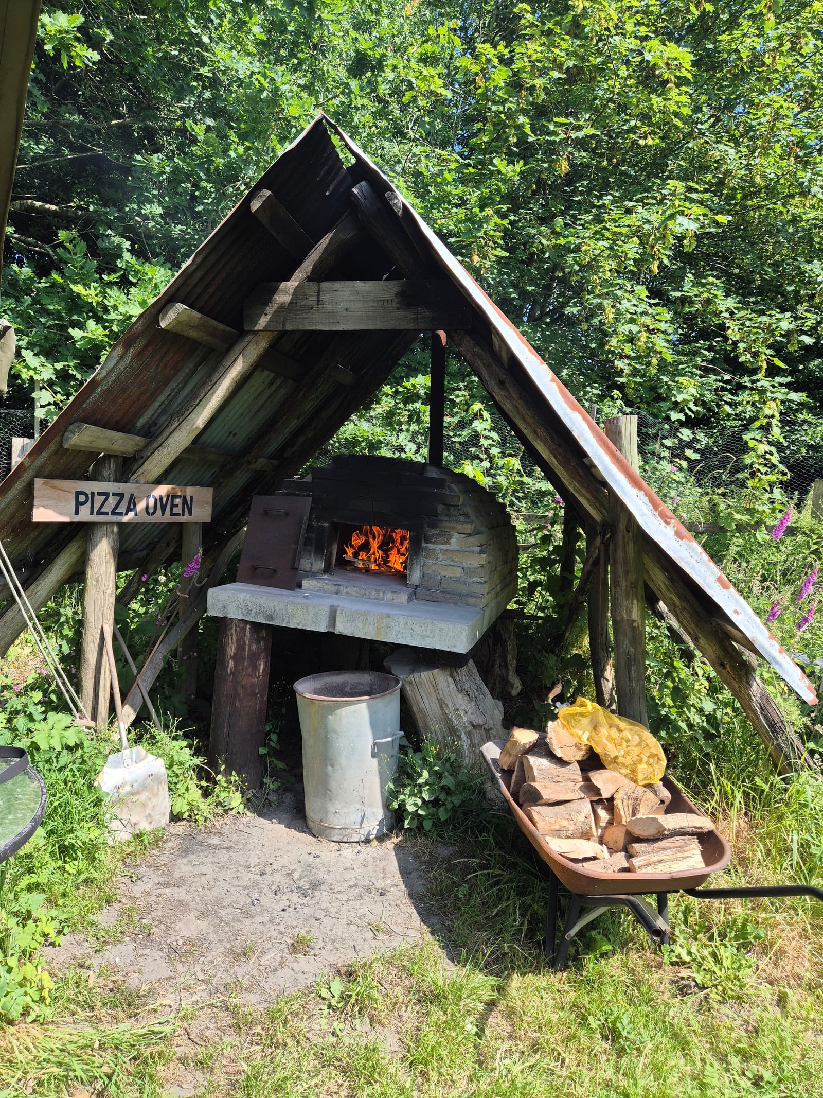 Wood-fired pizza oven under a timber shelter