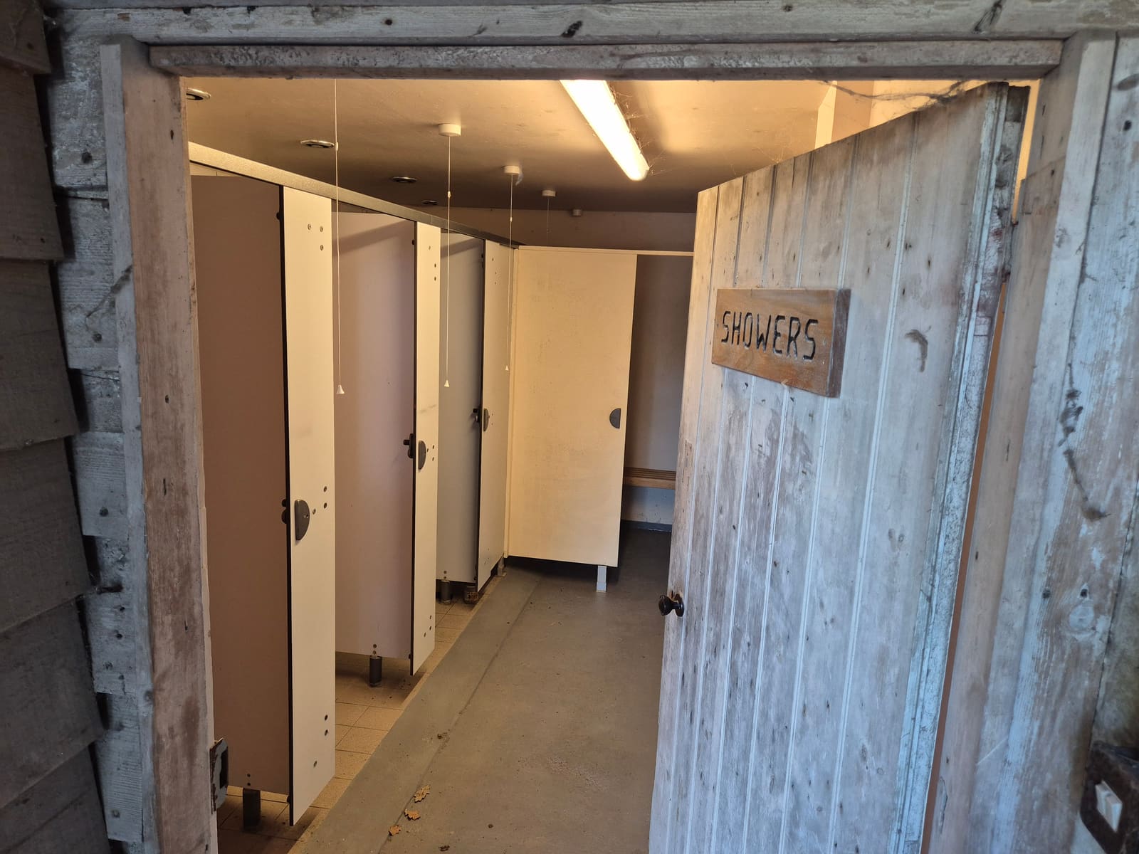 The shower block with a rustic wooden Showers door