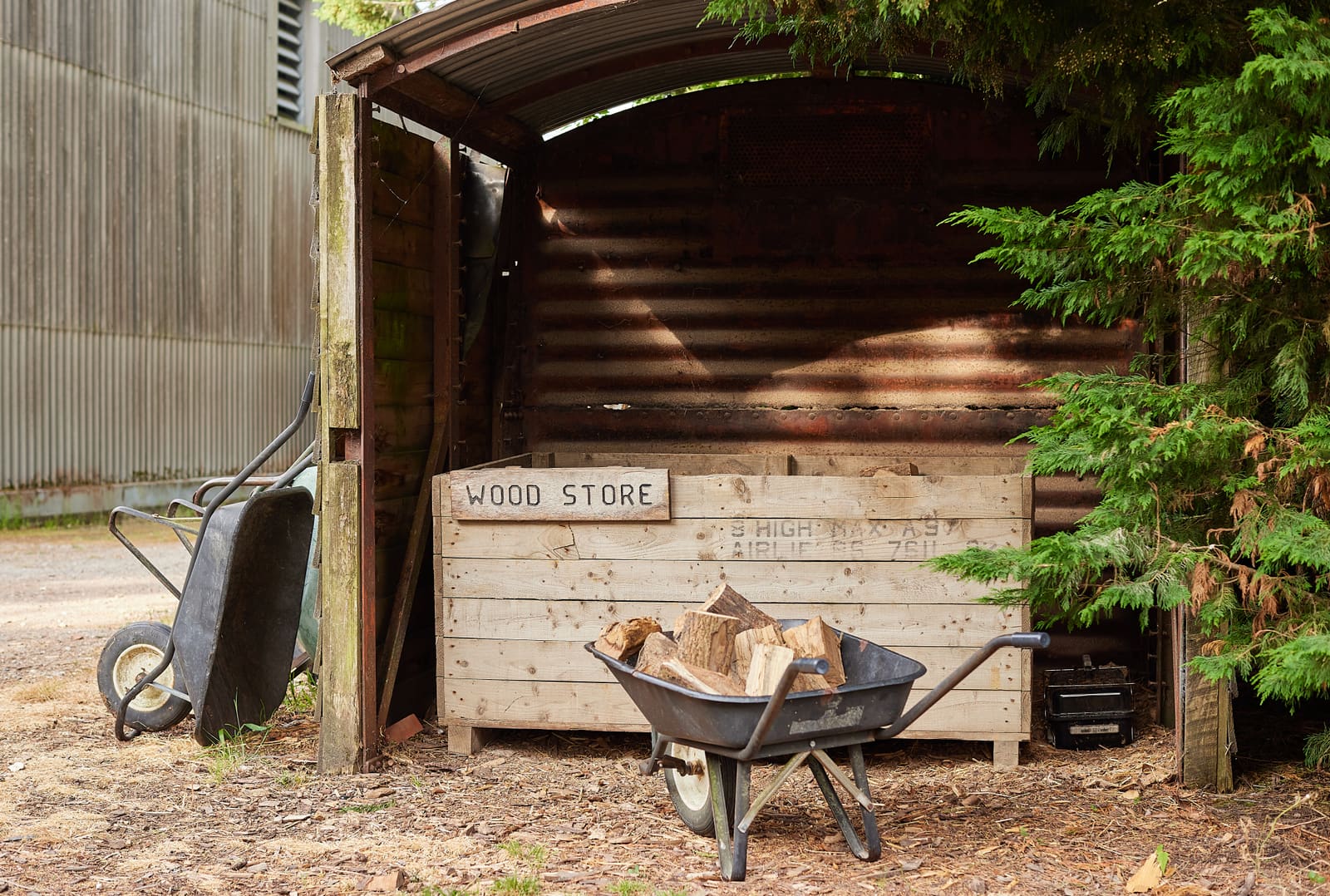 The wood store with a wheelbarrow of logs